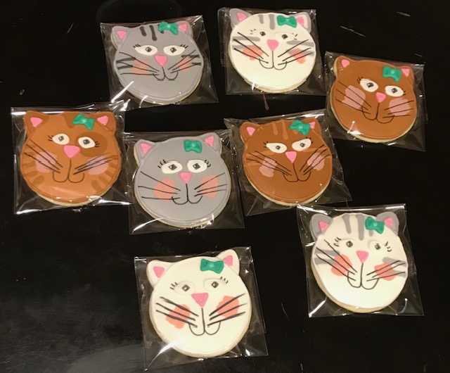Cookies decorated like a cat face with a smile and whiskers.