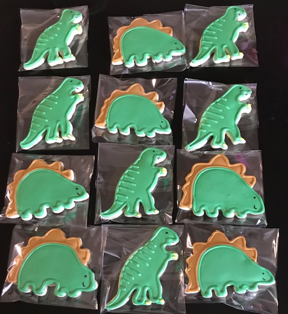 Cookies designed with a dinosaur theme colored green.