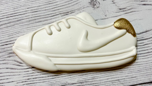 Sugar cookie shoe white checkmark with gold close-up.